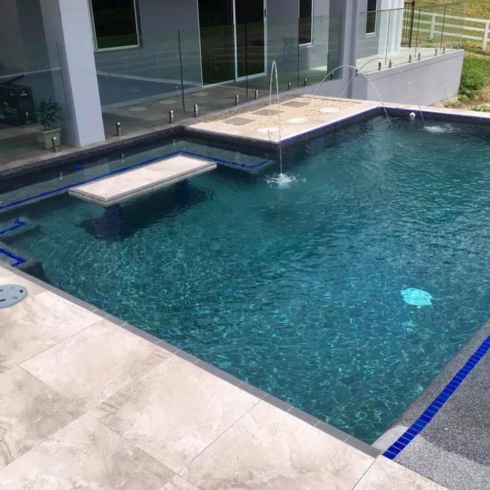 Swimming pool with a stone deck and dark blue water— Tru Blu Pools & Spas in Bluewater, QLD