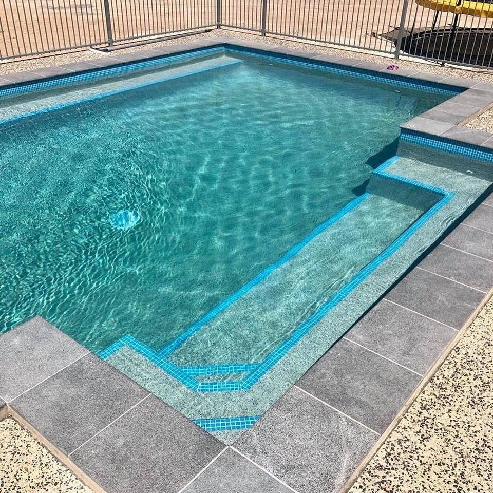 Swimming pool with turquoise water, steps, and gray tile surround— Tru Blu Pools & Spas in Bluewater, QLD