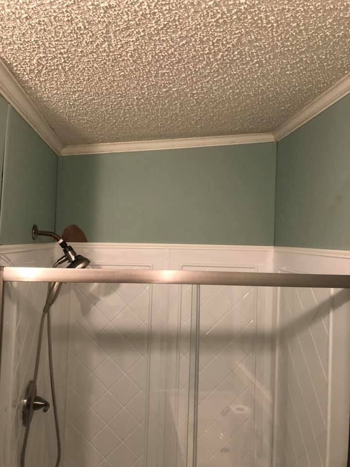 A bathroom with a shower stall and a shower head.
