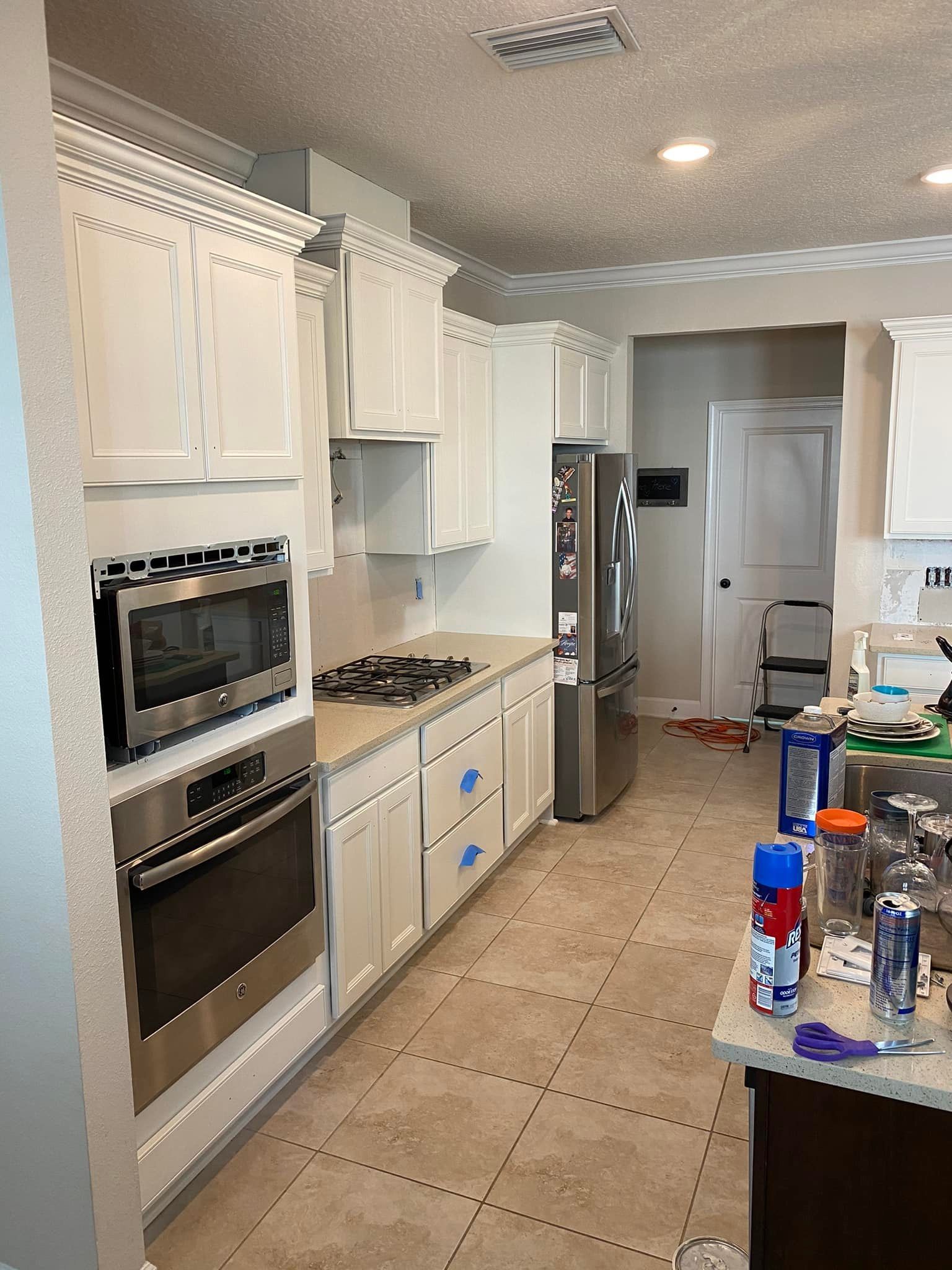 A kitchen with white cabinets and stainless steel appliances.