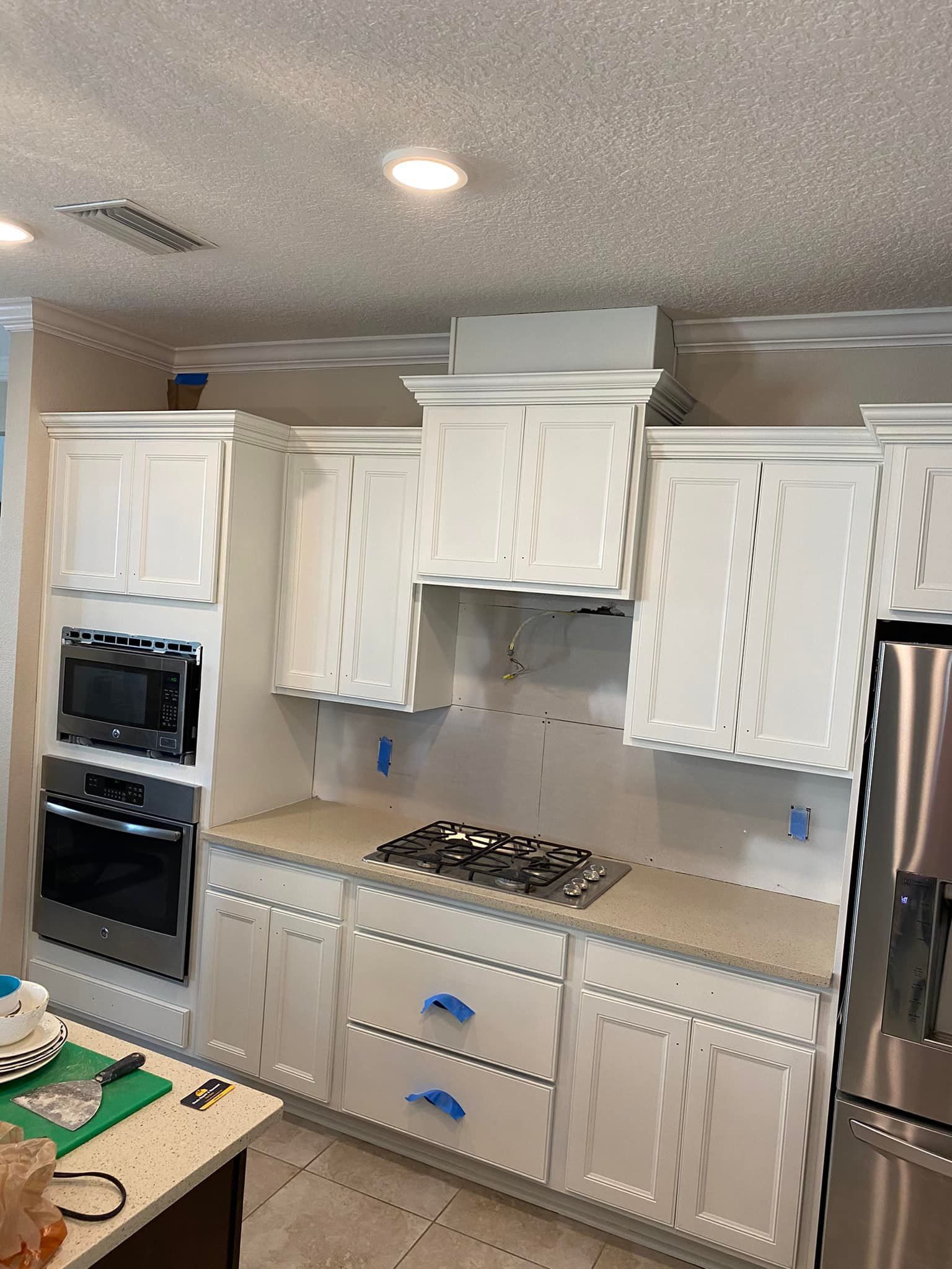 A kitchen with white cabinets and stainless steel appliances.