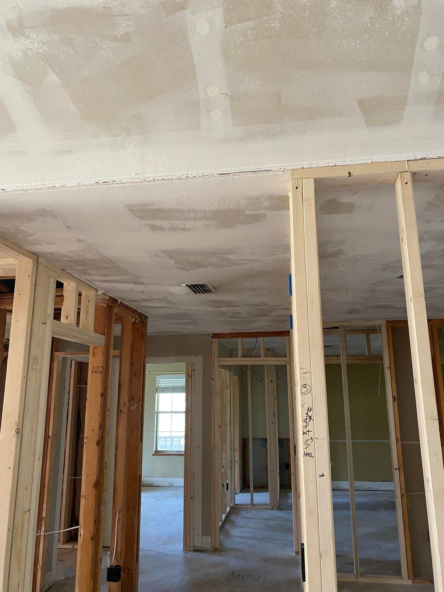 A room with a ceiling that is being built and a wooden frame.