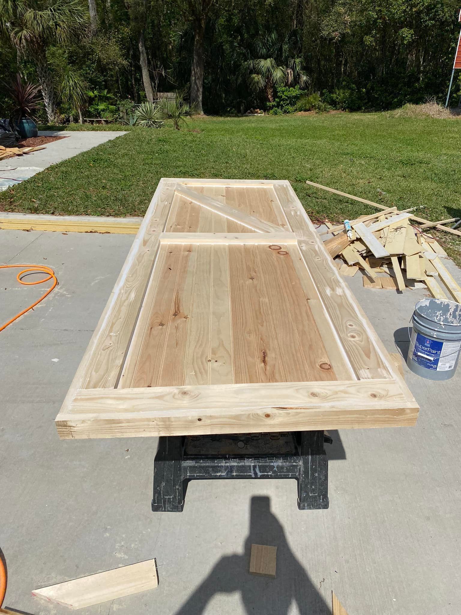 A wooden table is sitting on a workbench in a driveway.