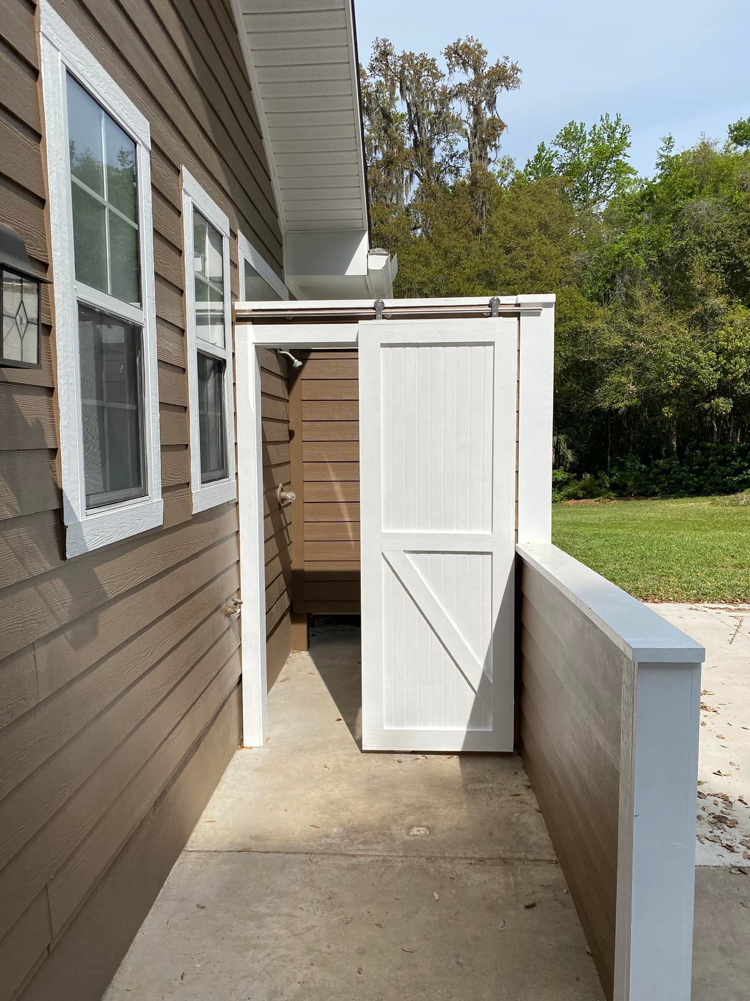 A white door is open on the side of a house.