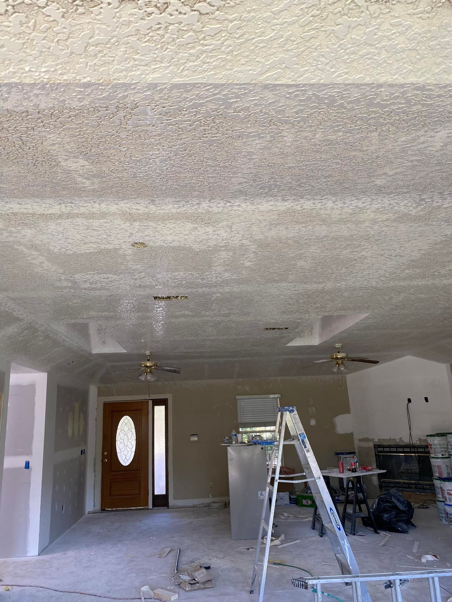 A room with a ladder in it and a ceiling fan.
