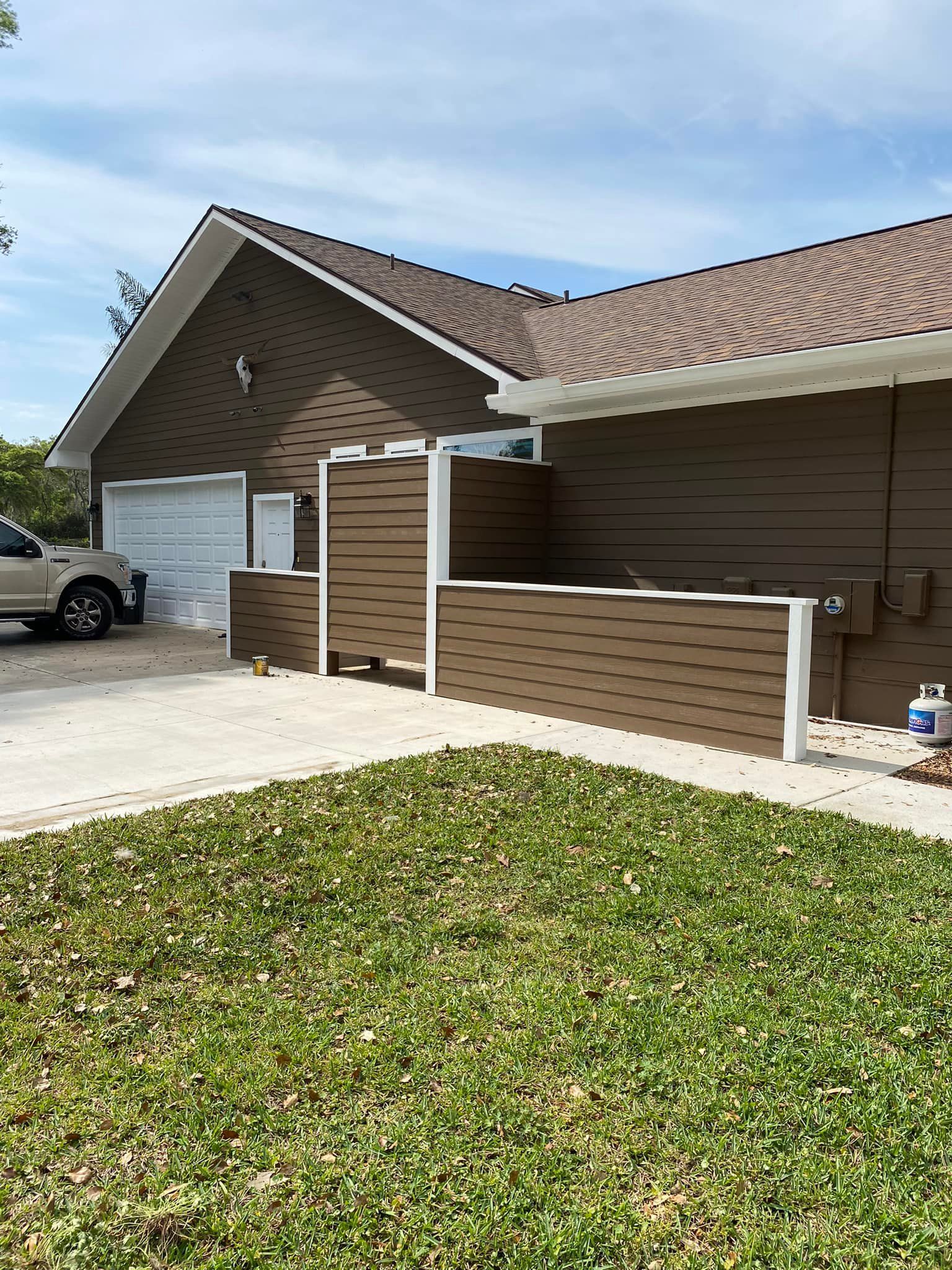 A brown house with a white truck parked in front of it.