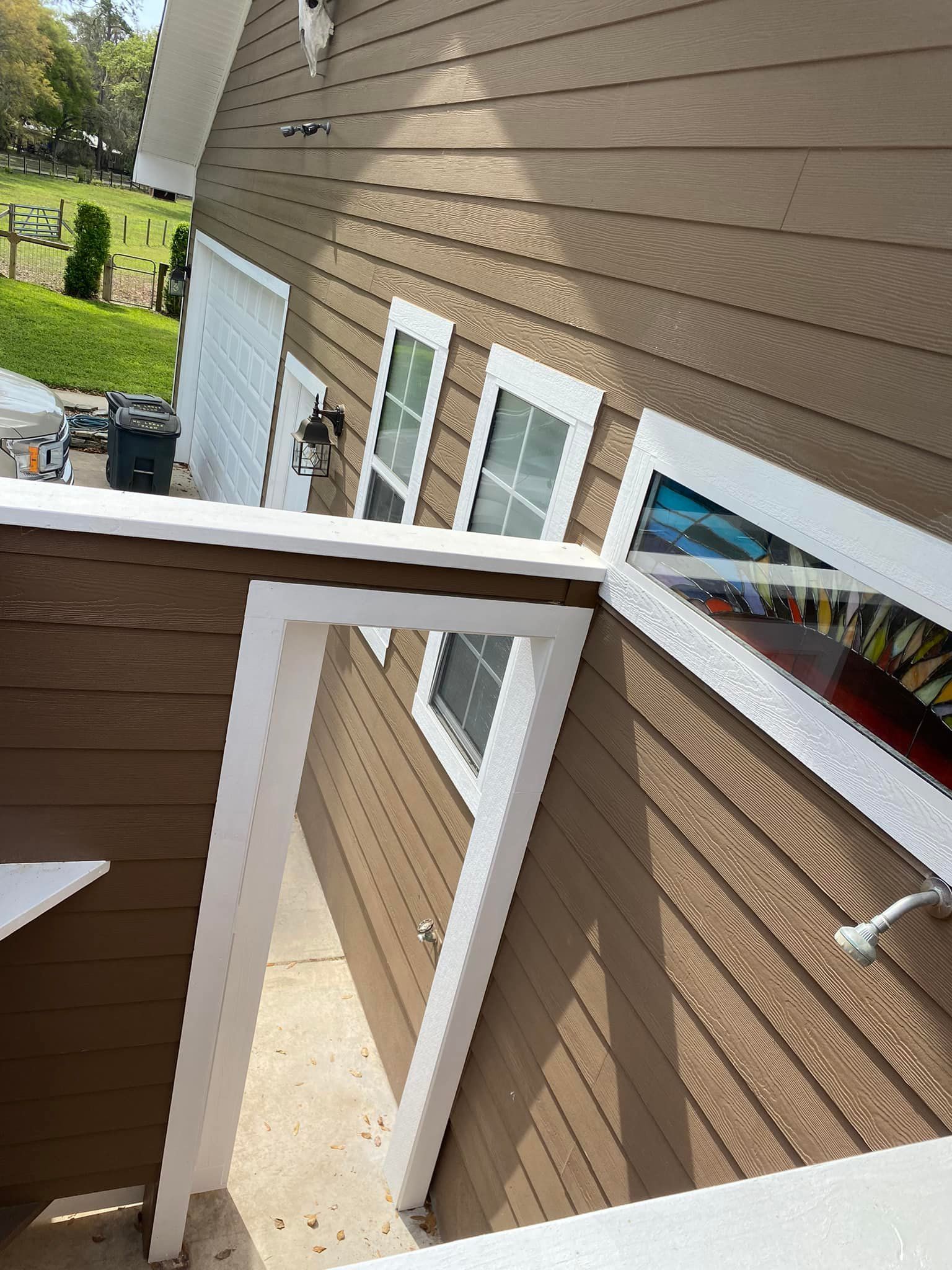 A brown house with white trim and a lot of windows.