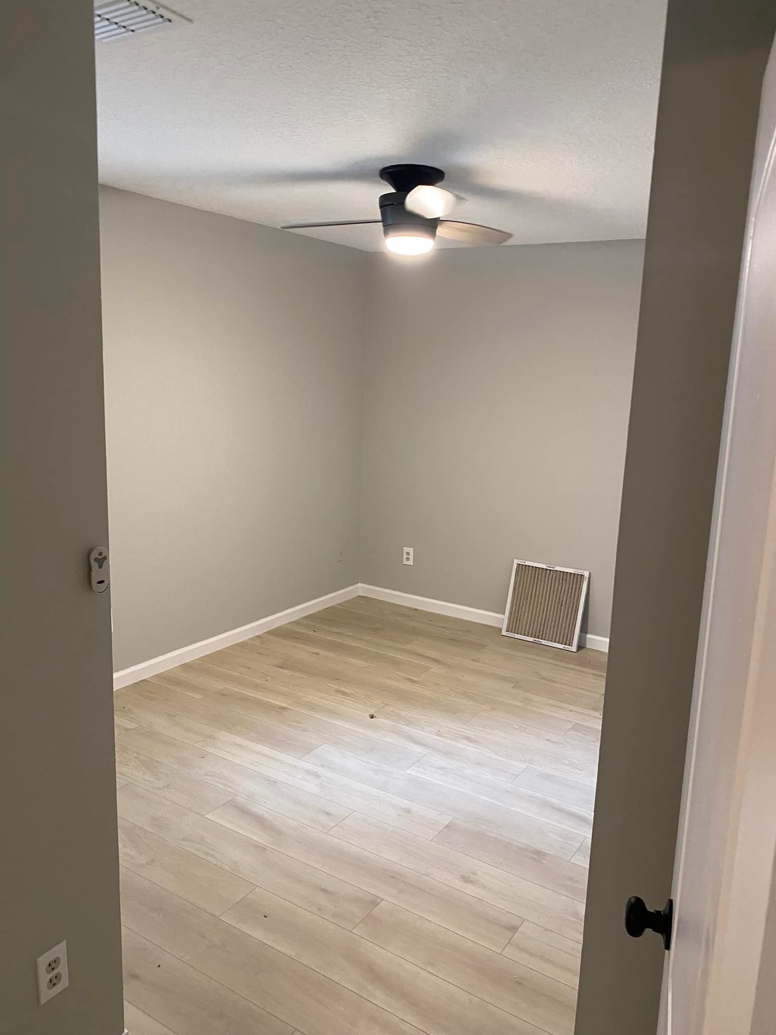 There is a ceiling fan in the room and a picture on the wall.