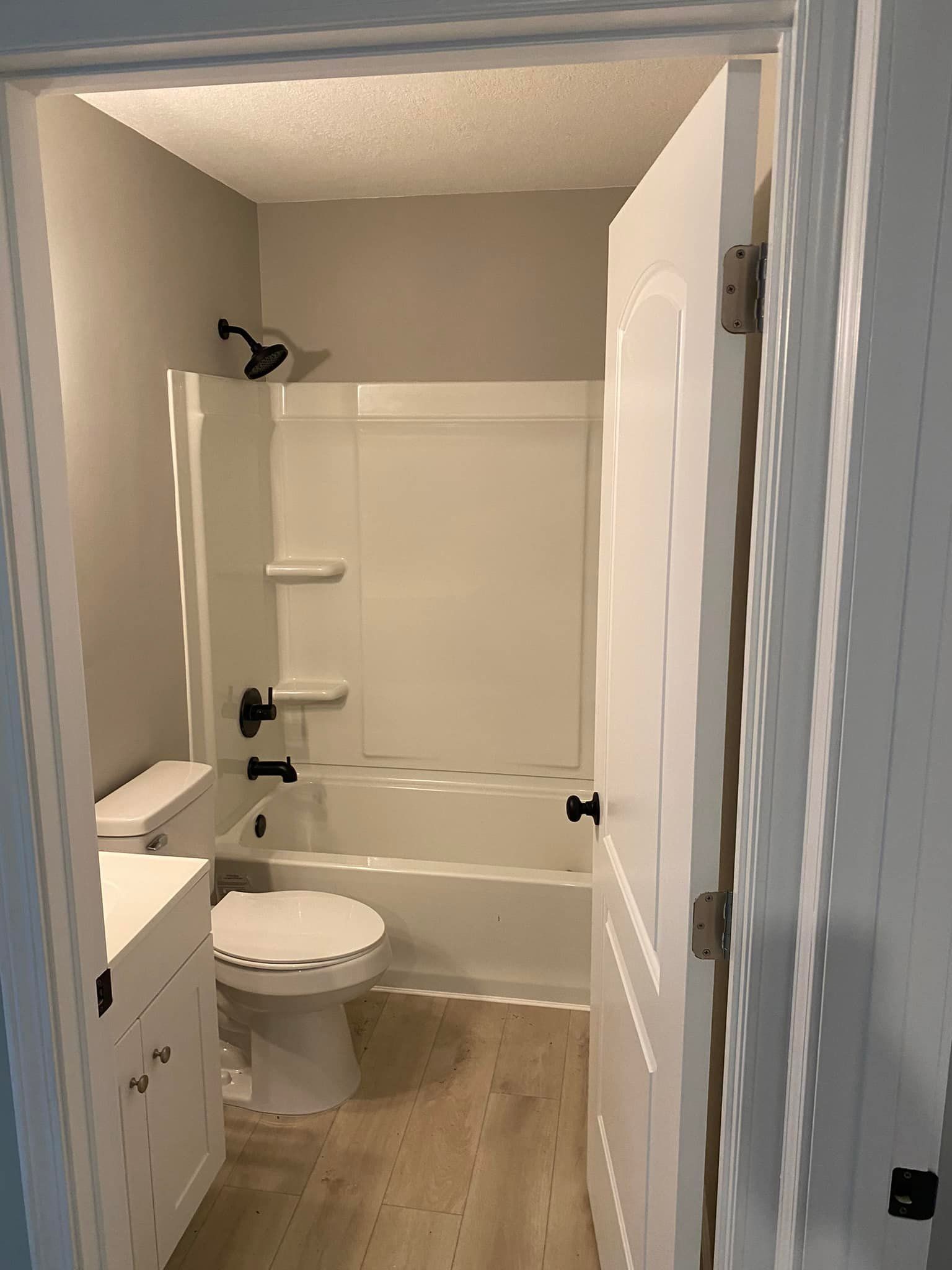 A bathroom with a toilet , bathtub and shower.