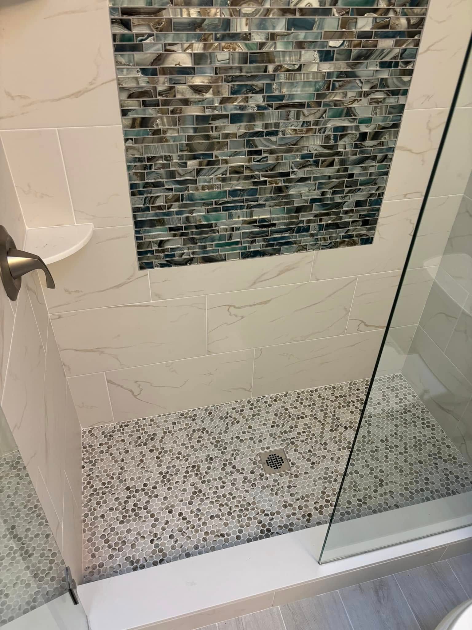 A bathroom with a walk in shower and a tiled wall.