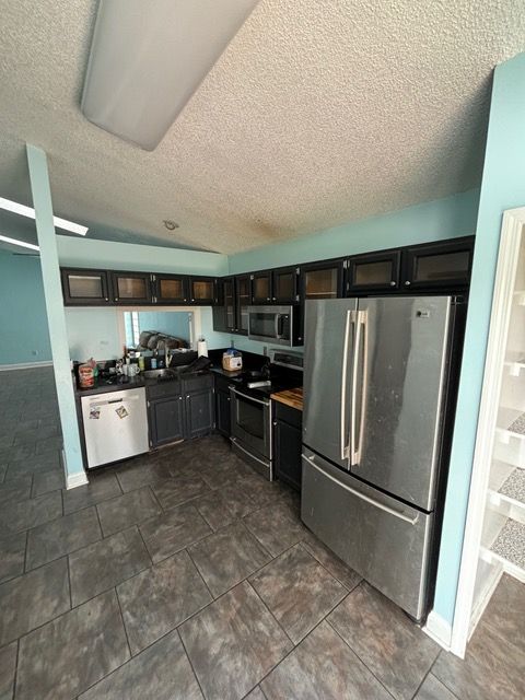 A kitchen with stainless steel appliances including a refrigerator