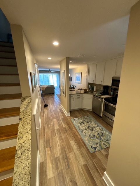 A hallway leading to a kitchen and stairs