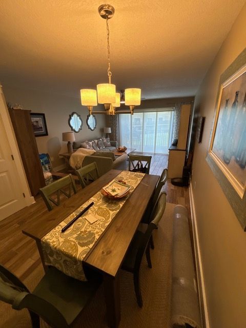 A dining room with a table and chairs and a chandelier