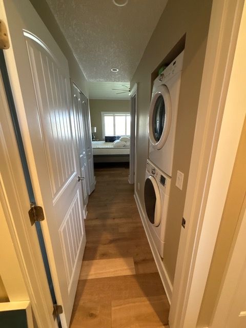 A hallway with a washer and dryer stacked on top of each other