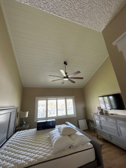 A bedroom with a bed and a ceiling fan