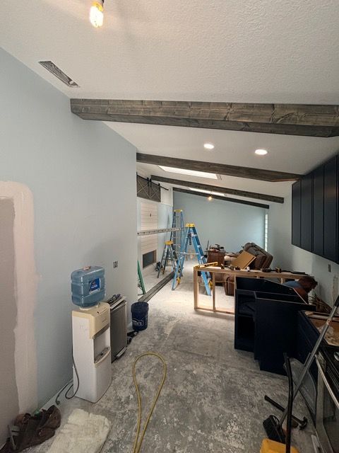 A living room with a water cooler and a ladder in it.