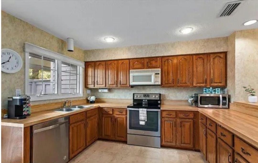 A kitchen with wooden cabinets and stainless steel appliances