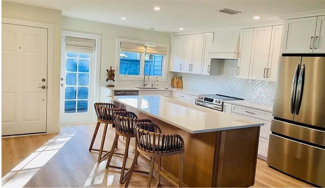 A kitchen with stainless steel appliances and a large island.