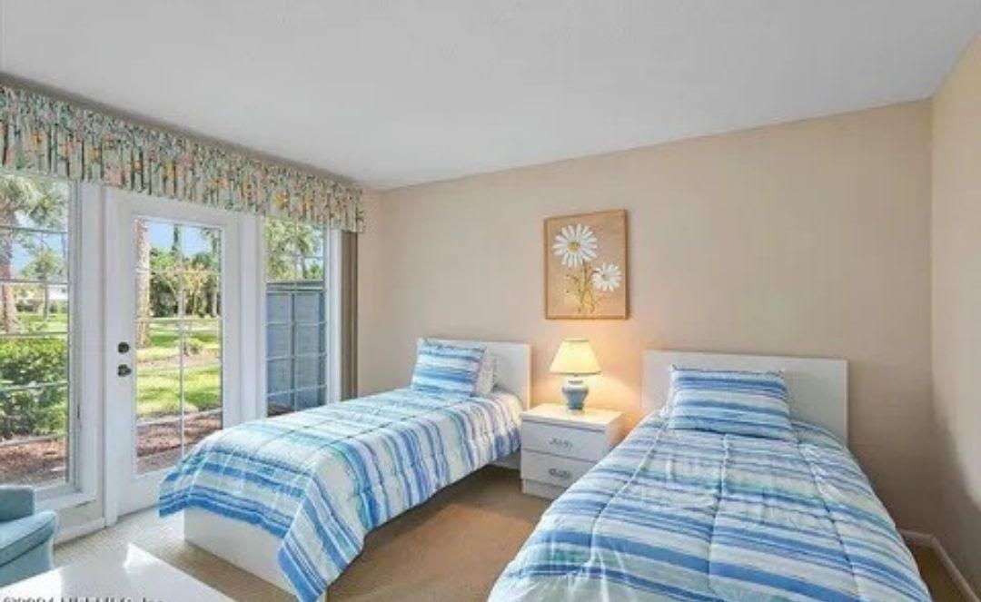 A bedroom with two twin beds and a sliding glass door.