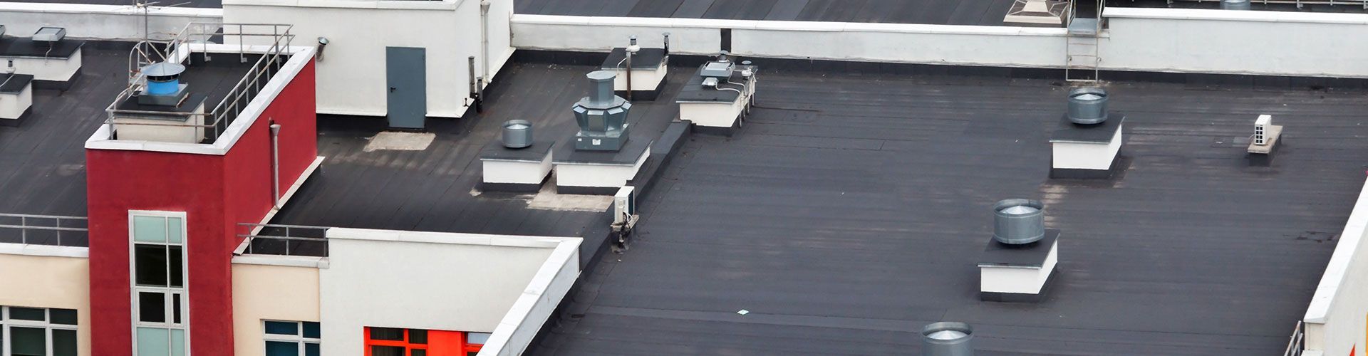 An aerial view of a rooftop of a building with a black roof.