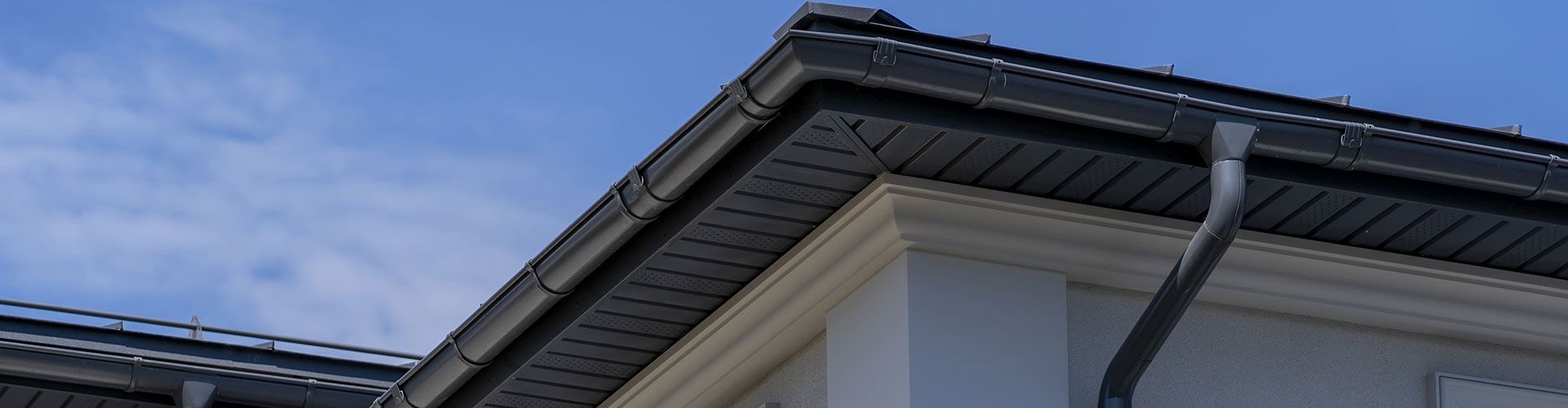 A close up of the roof of a building with a blue sky in the background.