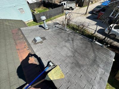 A man is sweeping the roof of a house with a broom.