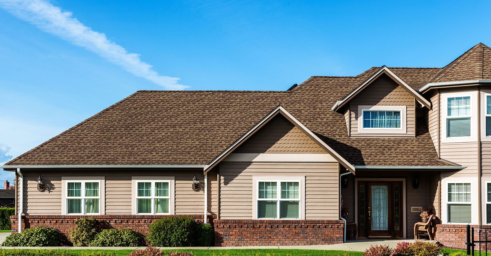 A large house with a brown roof and a lot of windows