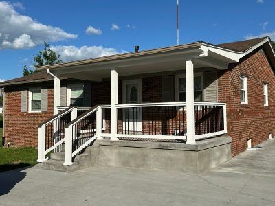 A brick house with a porch and stairs