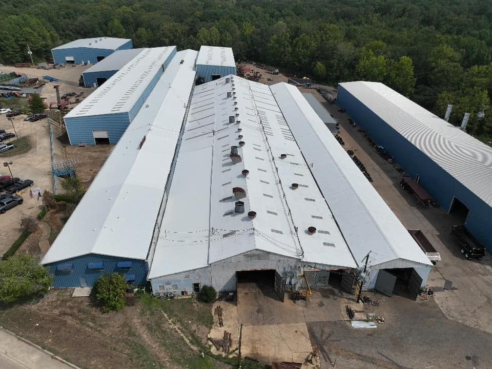 An aerial view of a large building with a white roof