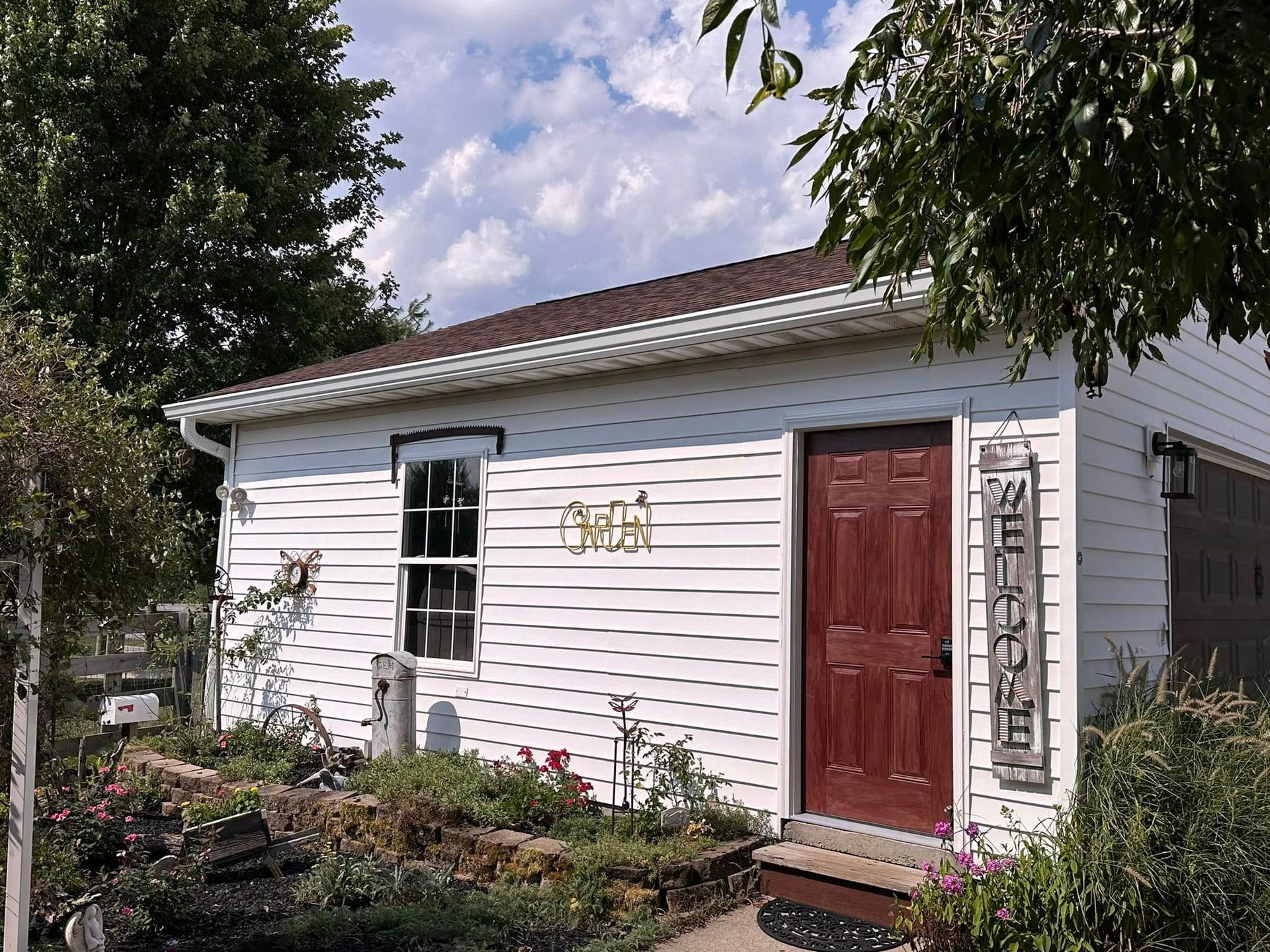 A white house with a red door and a sign that says ' smith ' on it