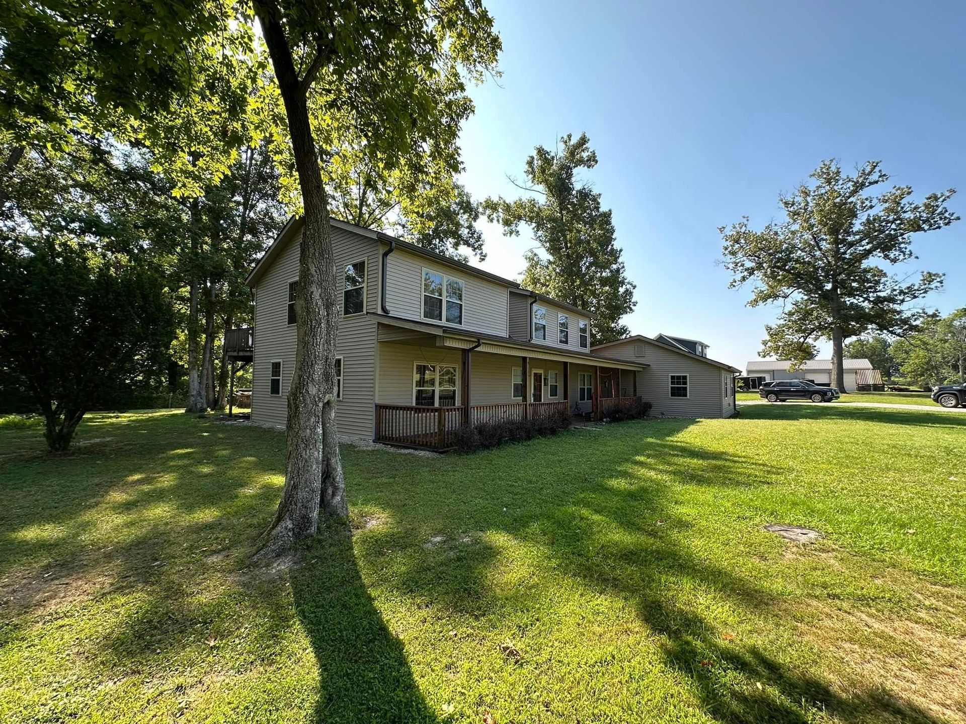 A house with a porch and trees in front of it