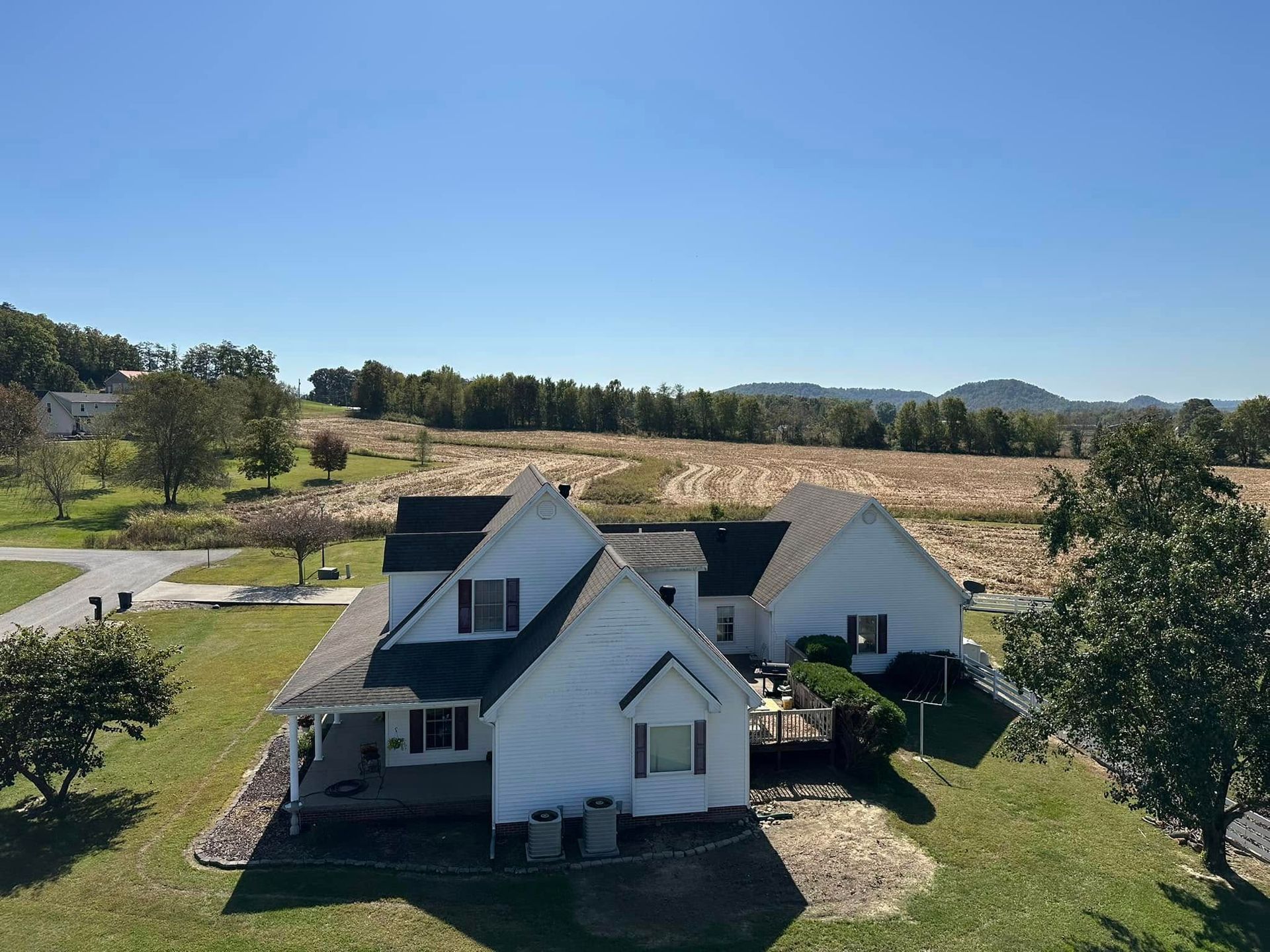 An aerial view of a white house with a black roof