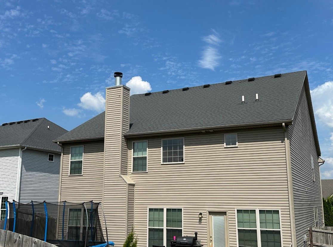 The back of a house with a trampoline in front of it.