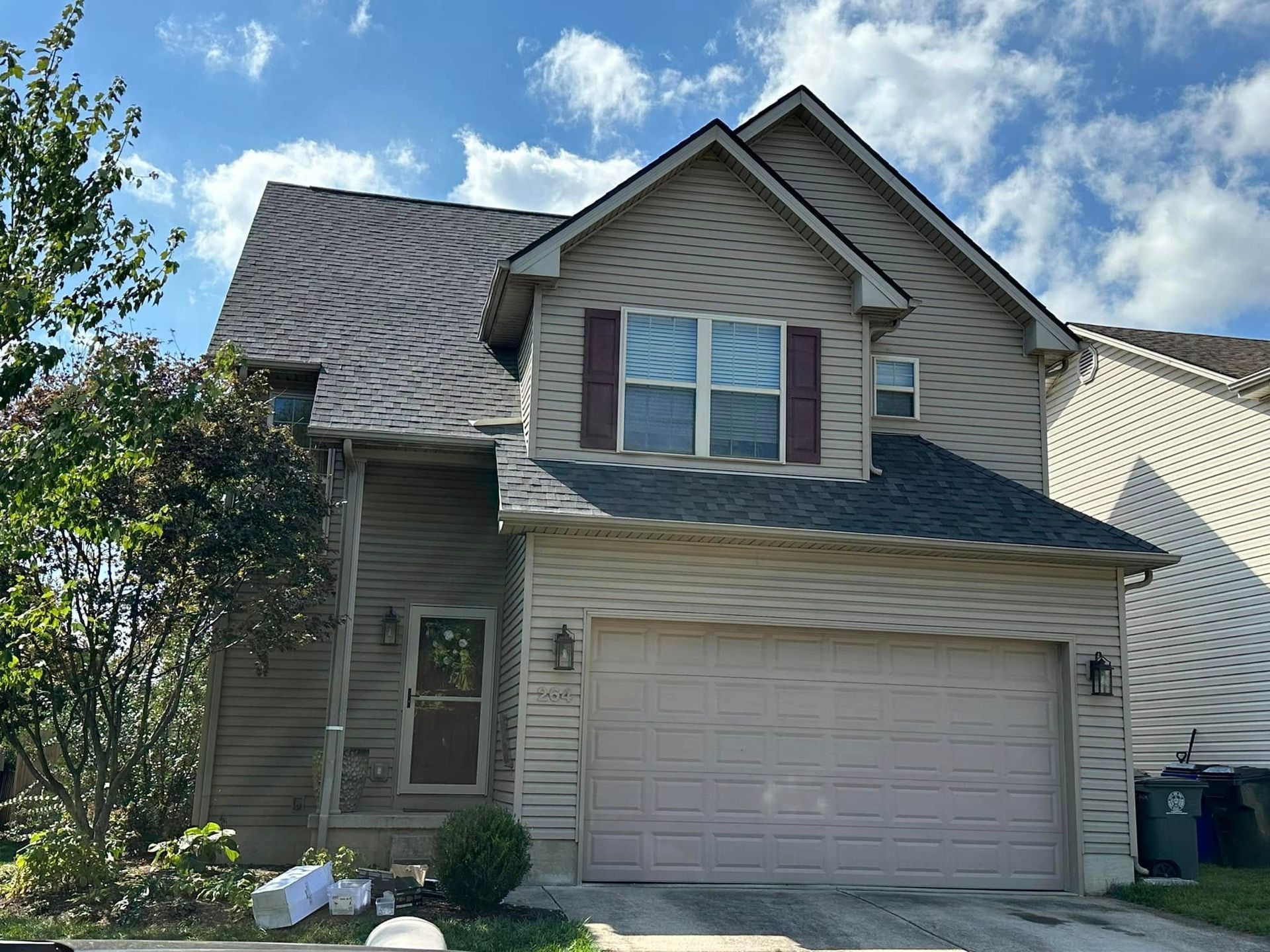 A large house with a garage and a blue sky in the background.