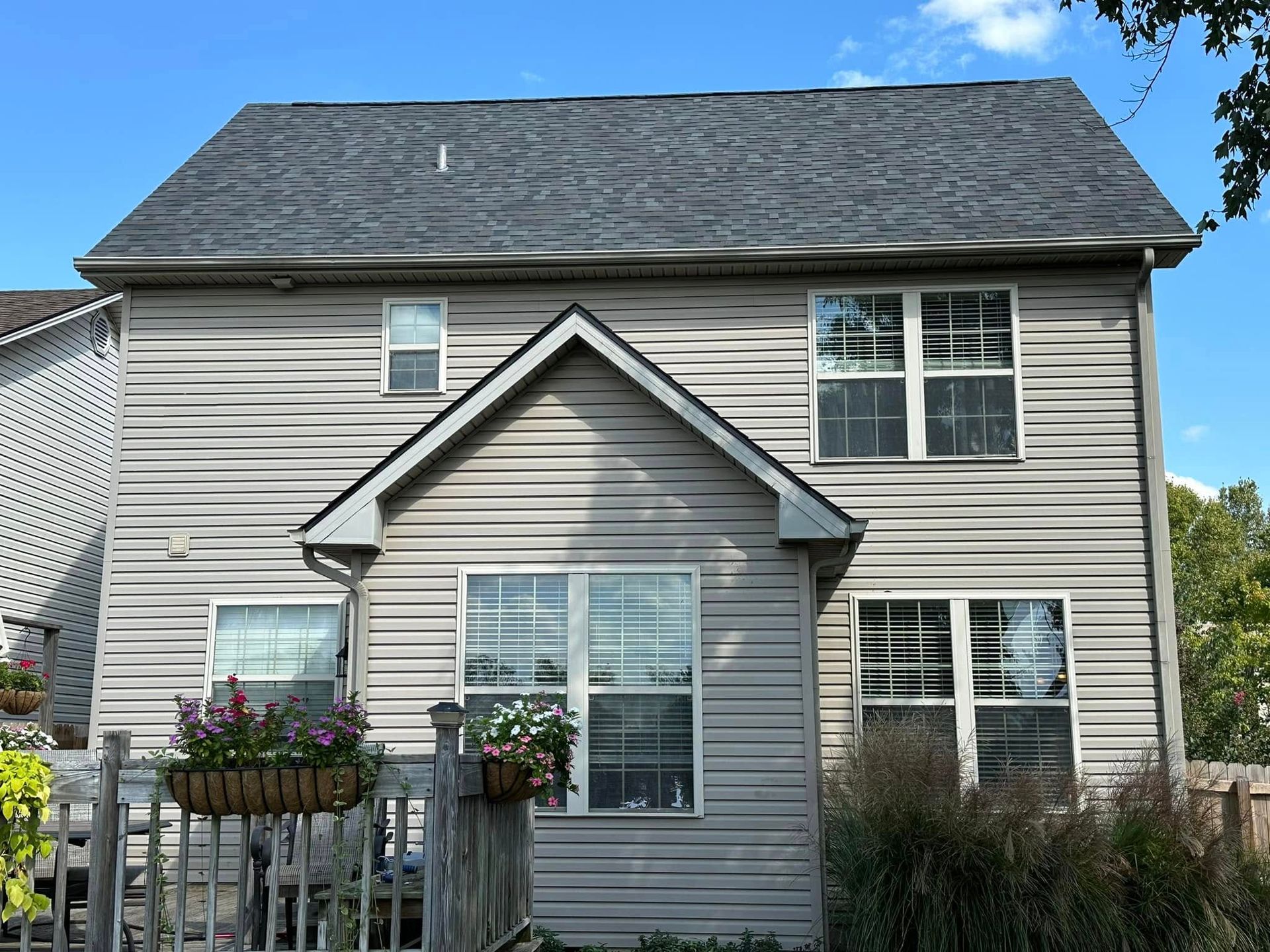 A house with a gray siding and a black roof