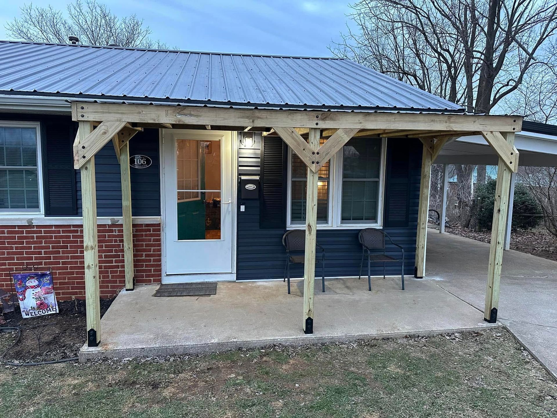 A small house with a wooden porch and a metal roof.