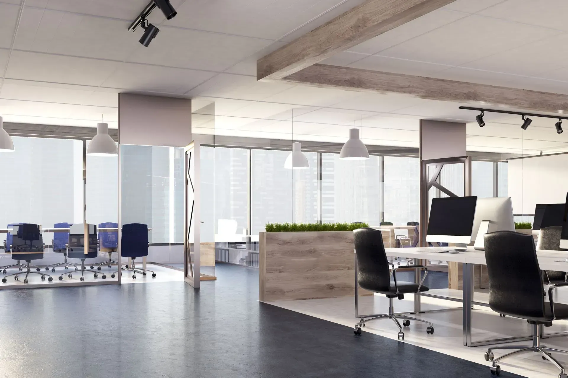 Modern, open-plan office with desks, chairs, large windows, and overhead lighting.