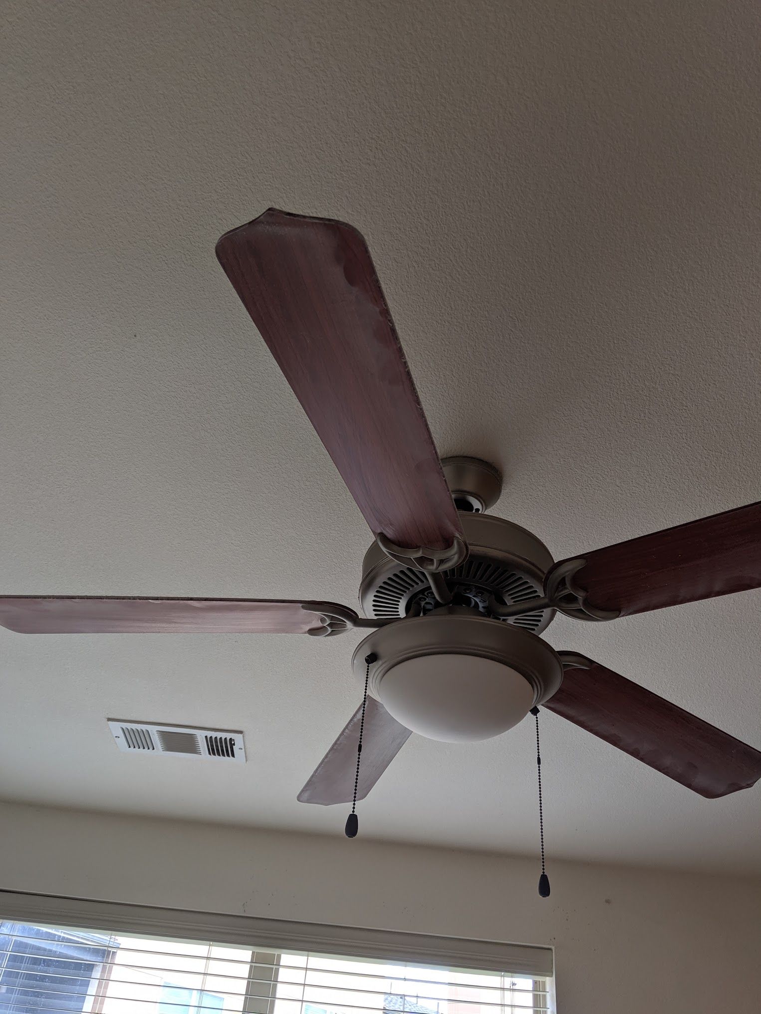 Ceiling fan with maroon blades and a light fixture.