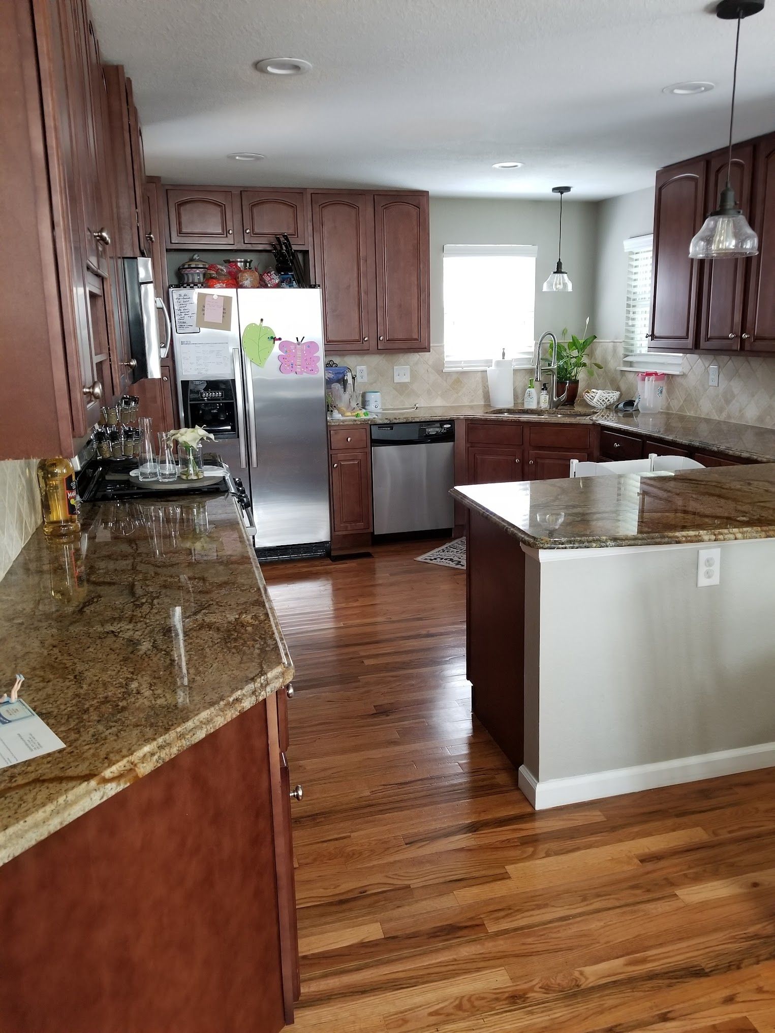Kitchen with wood cabinets, granite countertops, stainless steel appliances, and hardwood floors.