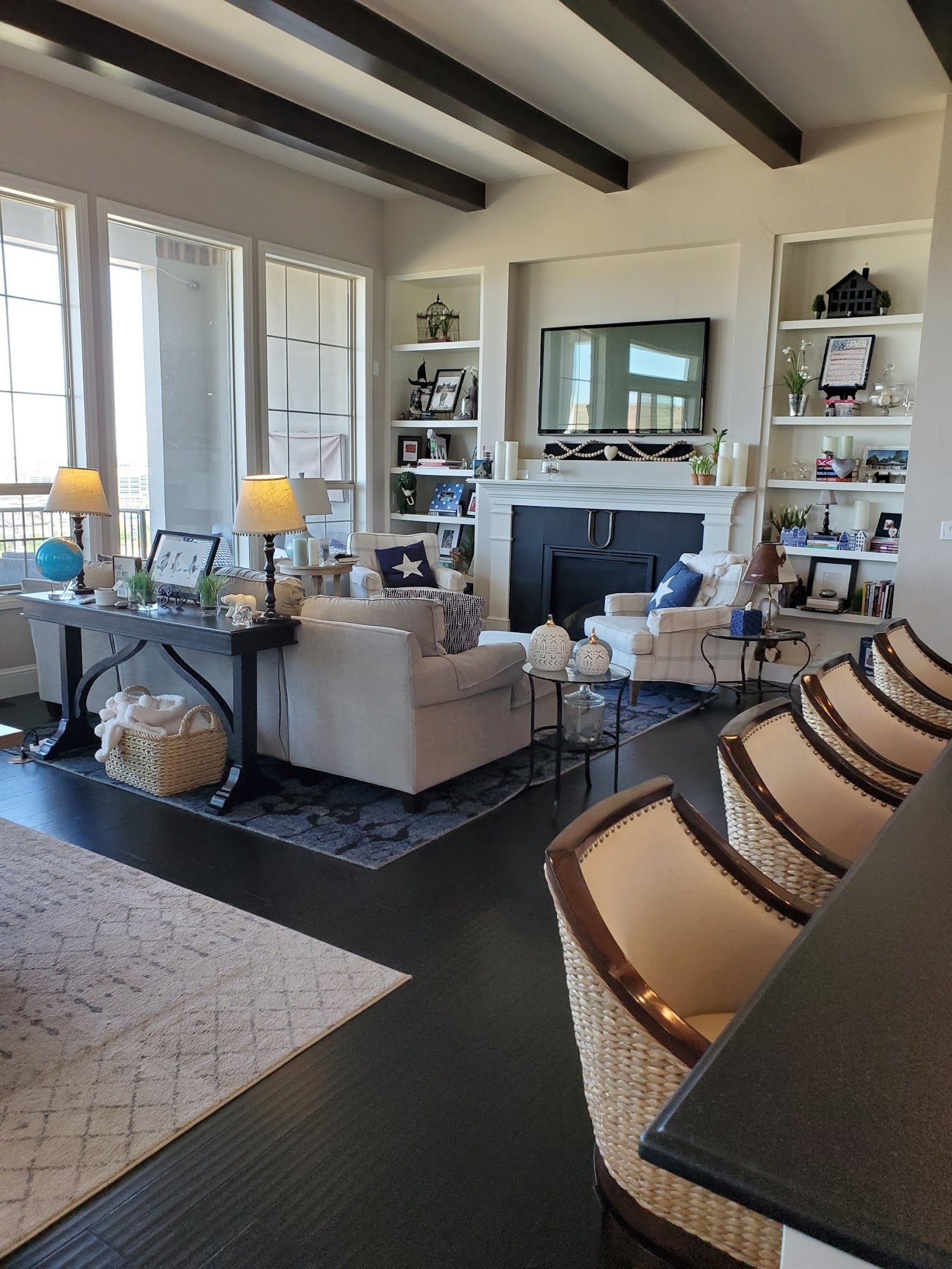 Living room with dark wood floors, a white sofa, fireplace, and bookshelves.