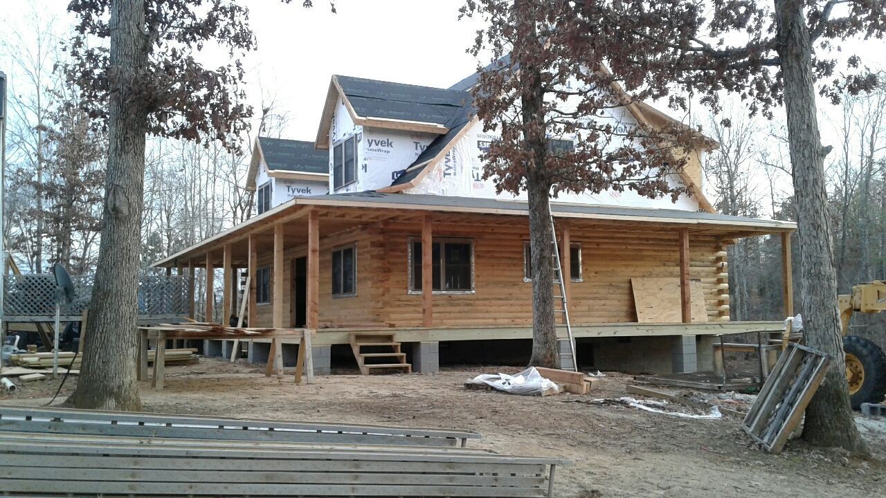 A large wooden house is being built in the woods