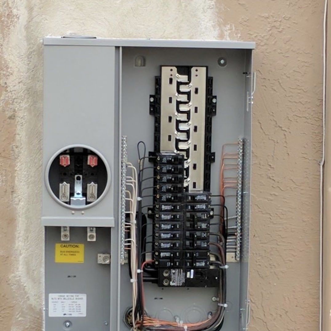 A gray electrical box on a wall with a yellow sign that says 