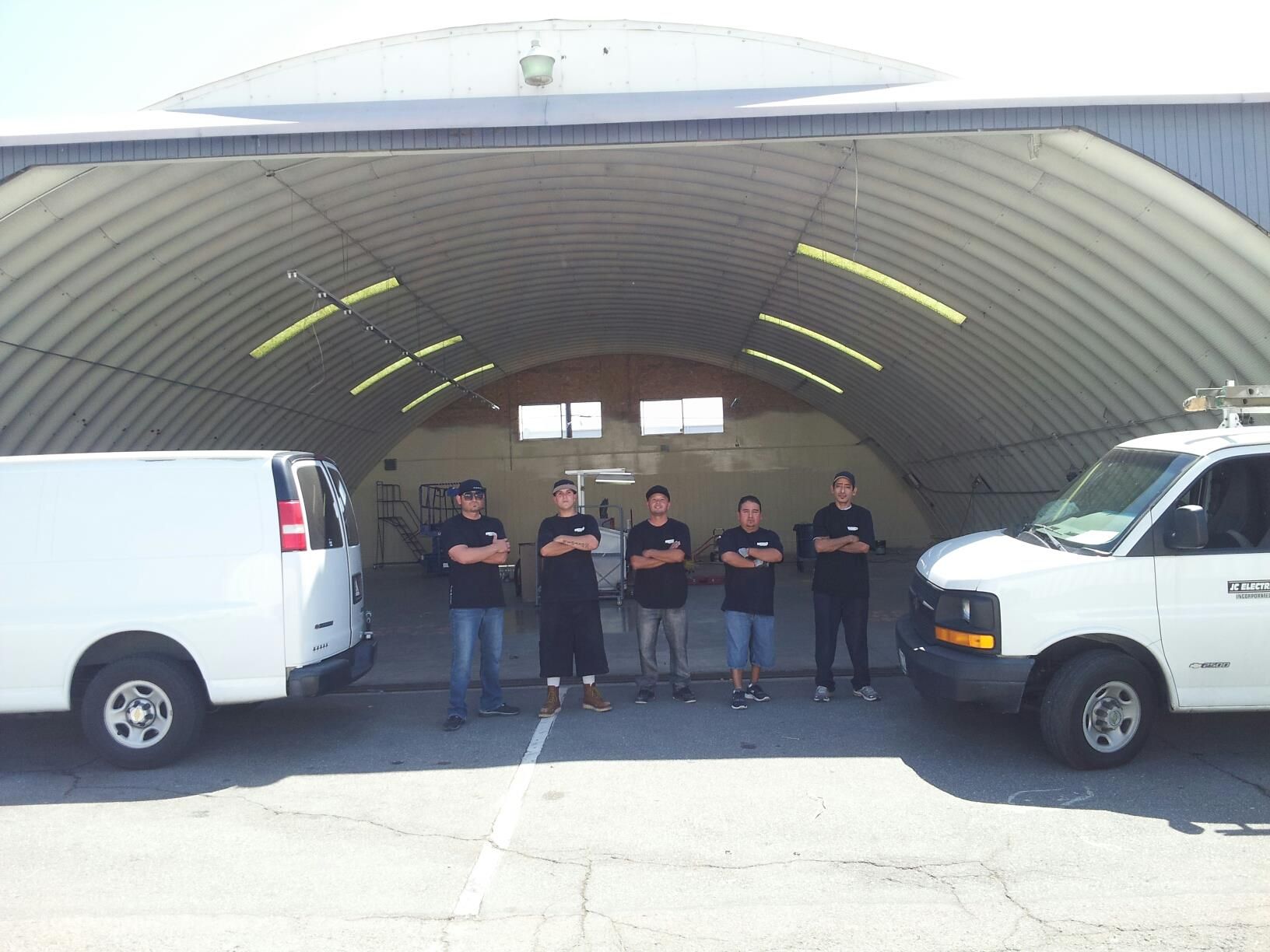 A group of men standing in front of two vans