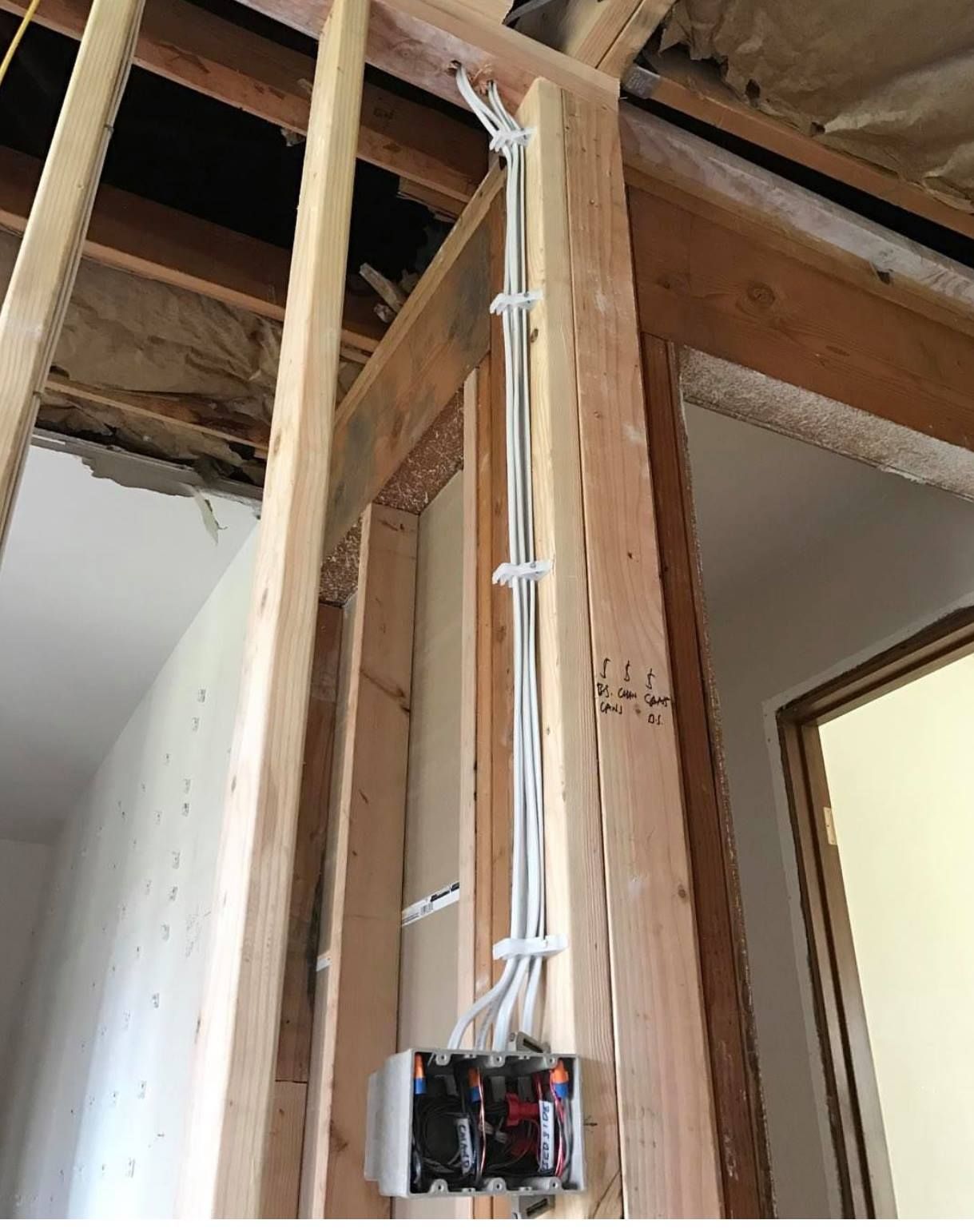 A box of wires is hanging from a wooden wall.