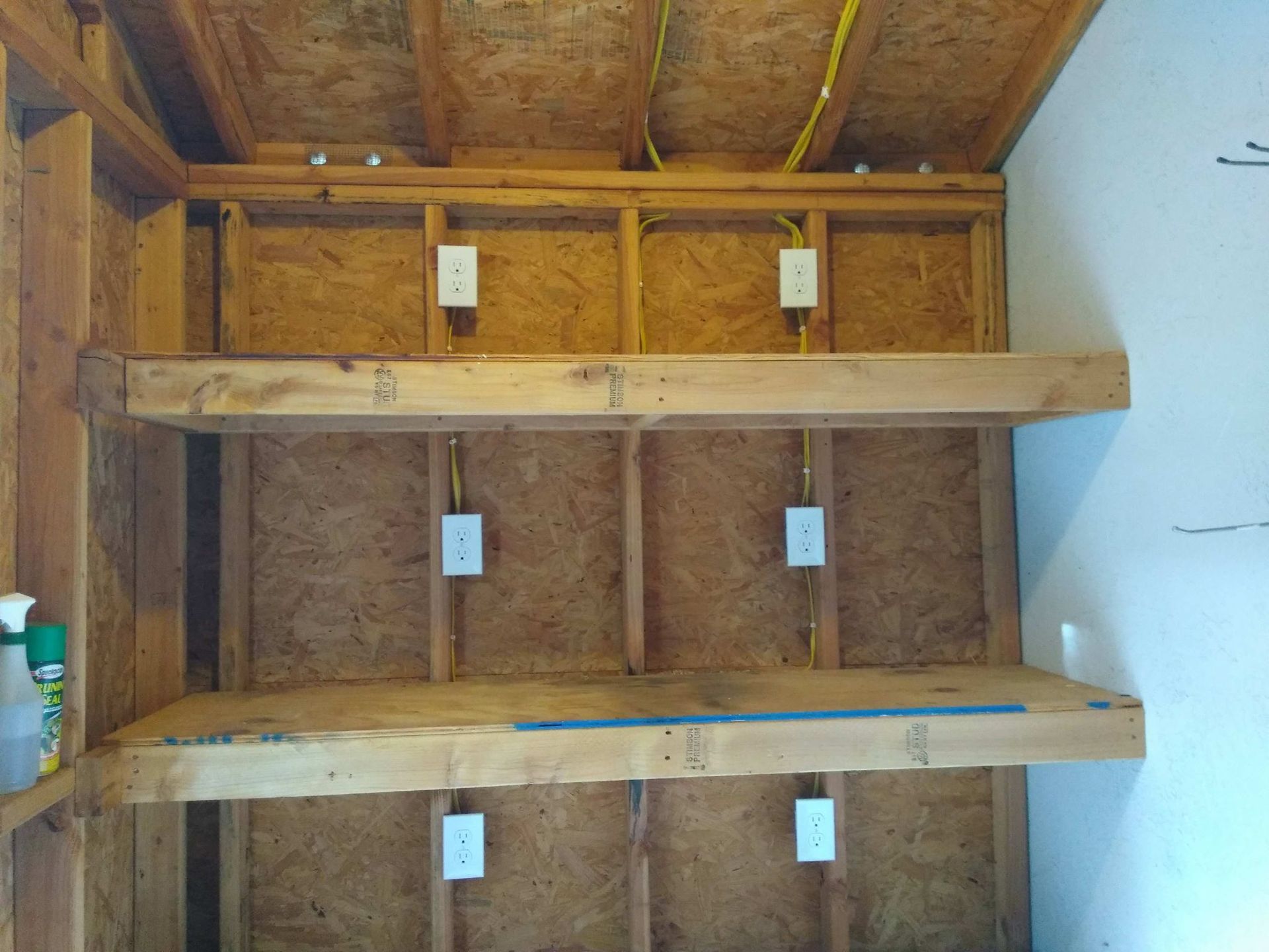 A room with wooden shelves and electrical outlets on the wall.