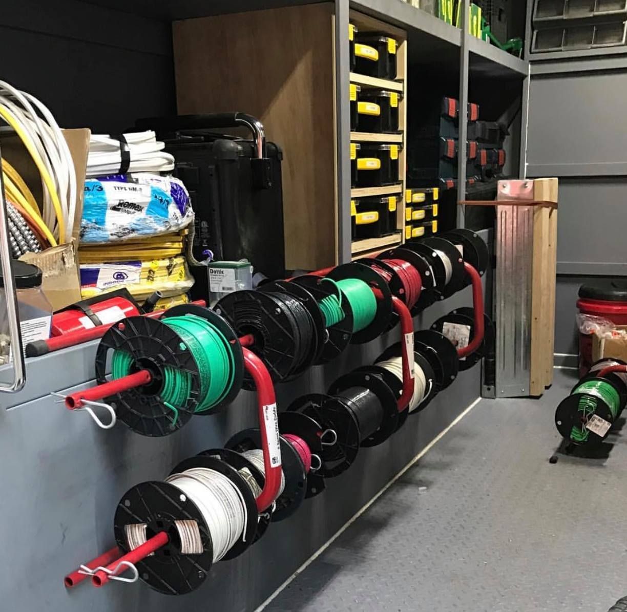 A bunch of spools of wires are lined up on a wall