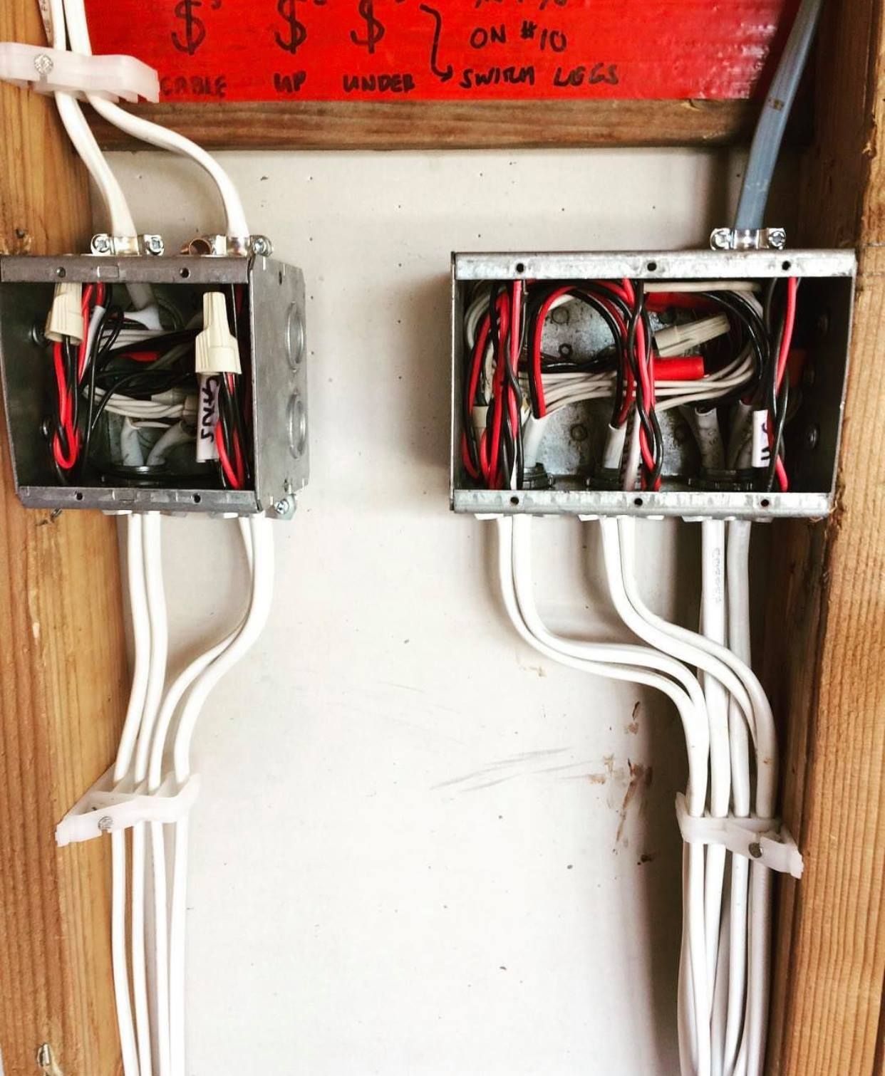 Two electrical boxes are connected to each other on a wall.