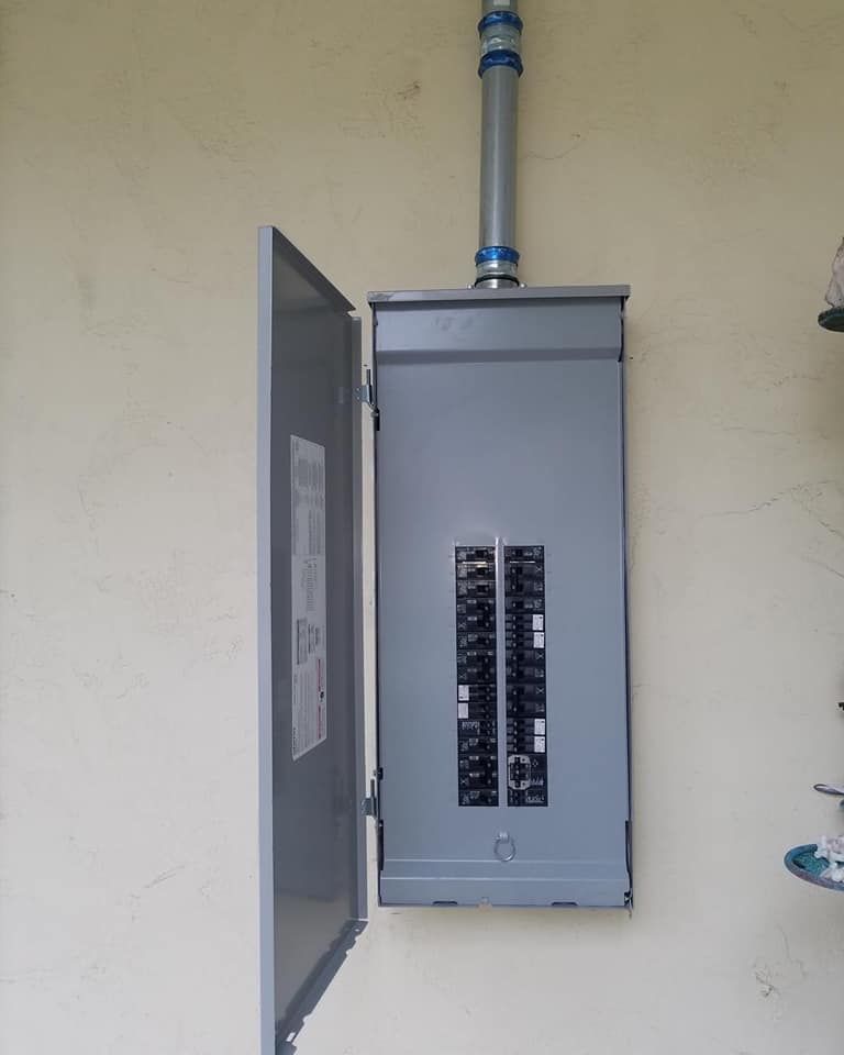 A gray electrical box is hanging on a white wall.
