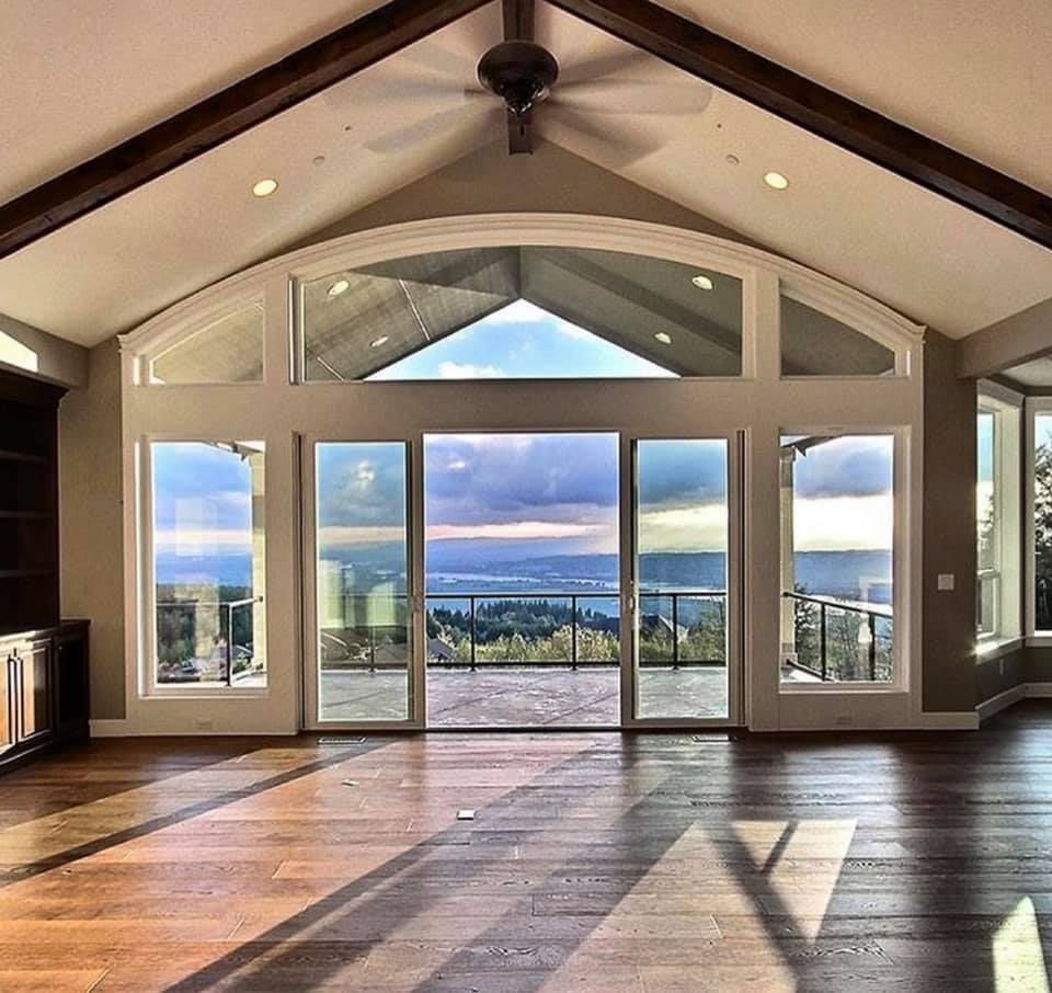 A large room with a lot of windows and a ceiling fan
