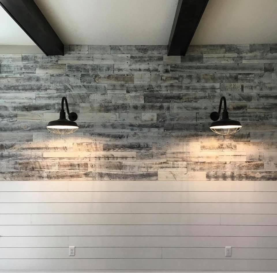 A wall with wood paneling and two lights on it.